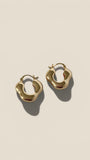 Gold hoop earrings on a beige background