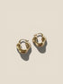 Gold hoop earrings on a beige background