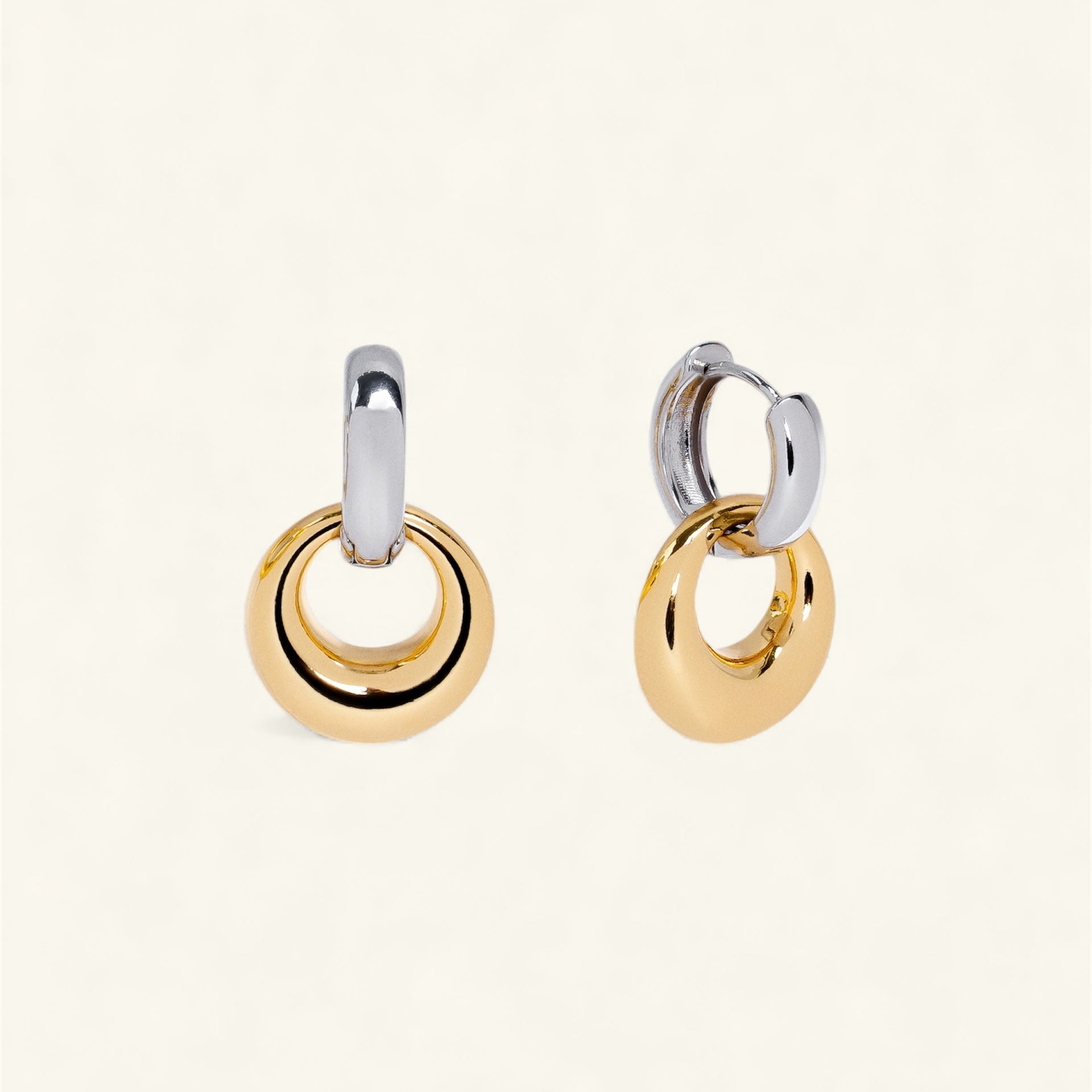 Pair of gold and silver hoop earrings on a white background