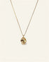 Gold necklace with a teardrop-shaped pendant on a light beige background